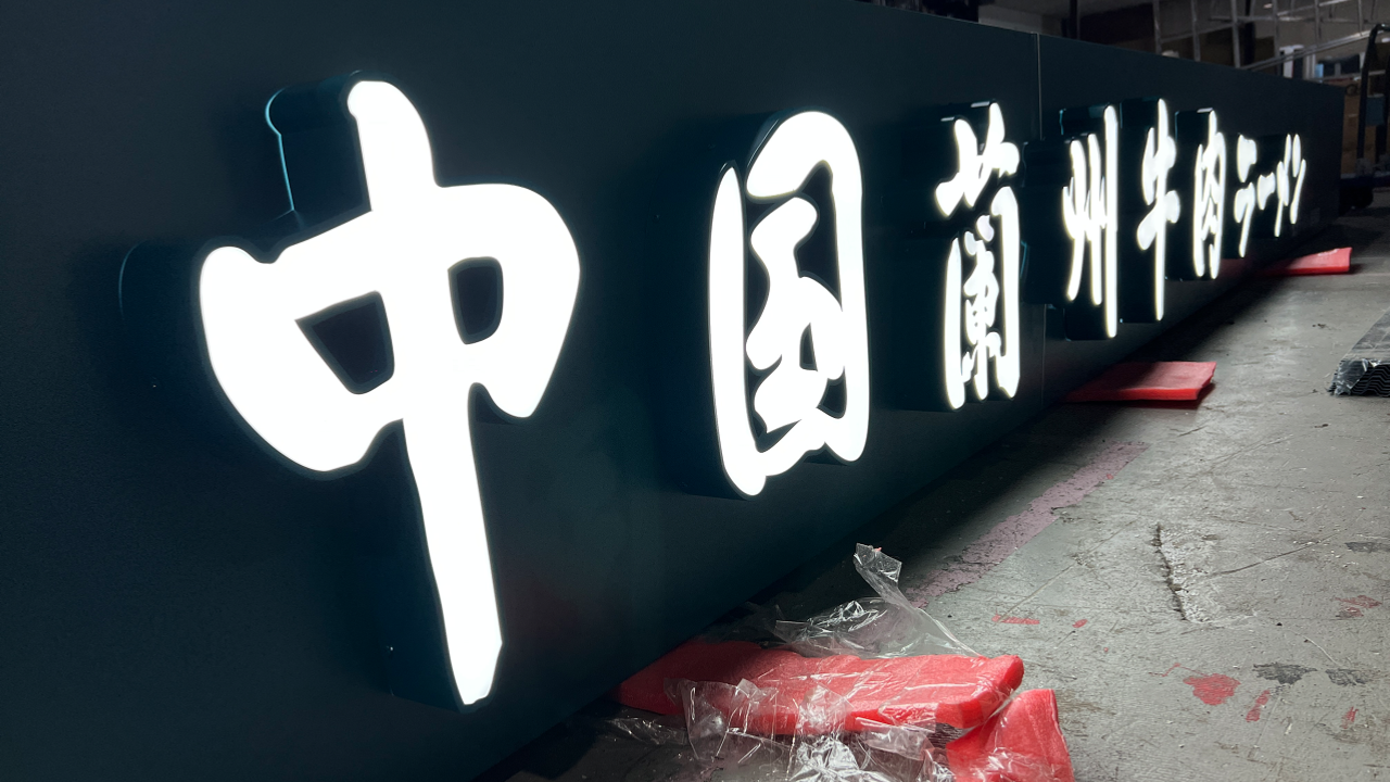 濃緑色のバックボードに取り付けた白色の正面発光チャンネル文字