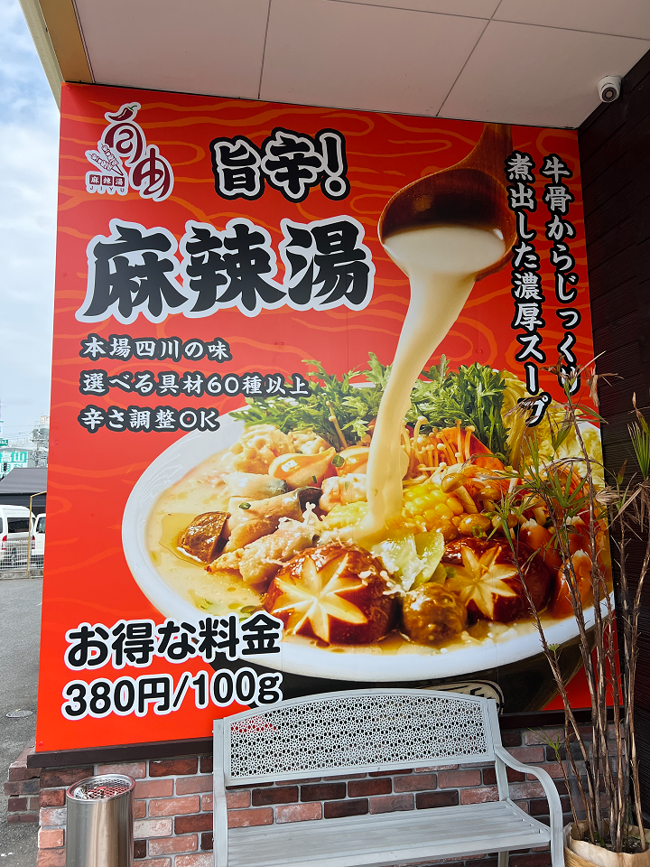 麻辣湯と牛骨スープを表示した店舗入口横の壁面看板